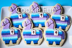 decorated cookies in the shape of elephants on a white plate with blue and purple icing