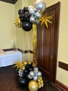 black and gold balloons are on display in front of a door