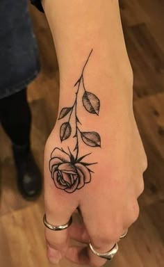 a woman's hand with a rose tattoo on it