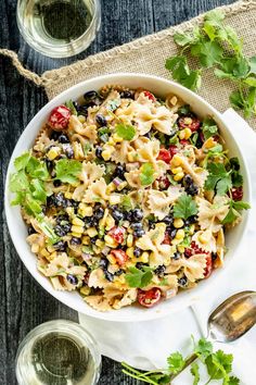 a white bowl filled with pasta salad and garnished with cilantro