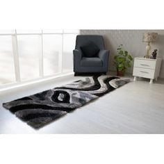 a black and white area rug with an abstract design on the floor next to a chair