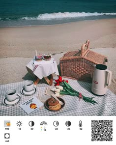 a picnic table with food and drinks on the beach