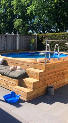 an above ground pool with steps leading up to it and a dog laying on the deck