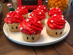 cupcakes with red frosting and white sprinkles on a plate