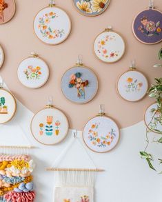 the wall is decorated with many different embroiderys and flowers on it, along with some plant hangers