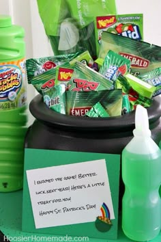 a pot full of candy with a note to someone on it and a bottle next to it