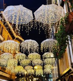 lighted umbrellas hanging from the side of a building