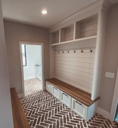 an empty room with some white cabinets and drawers on the wall next to a door