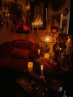 a living room filled with furniture and lit candles in front of pictures on the wall