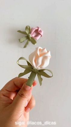 someone is holding a fake rose in their hand and it looks like they are made out of paper