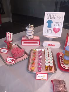 a table topped with trays filled with cupcakes and candy