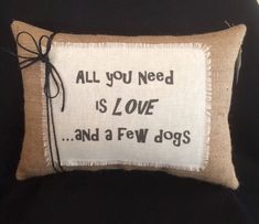 a pillow that says, all you need is love and a few dogs