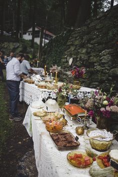 a long table with food on it in the woods