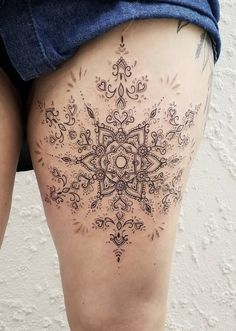 the back of a woman's thigh with an intricate tattoo design on her thighs