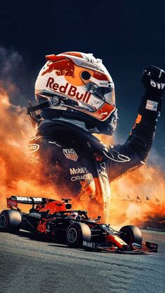 a red bull race car is on fire and it's driver has his fist up