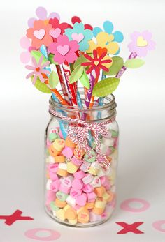 a jar filled with lots of candy and paper flowers