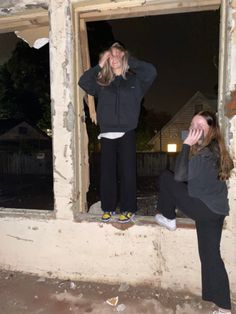 two people standing in an open window with their hands to their face and one person looking out the window