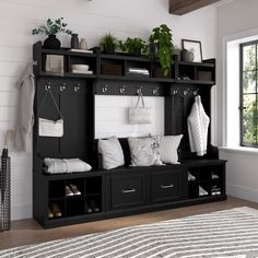 a black and white room with a bench, coat rack, pillows and other items