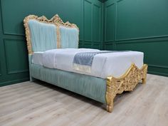 a bed that is sitting in the middle of a room with green walls and wood flooring