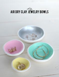 three bowls with jewelry in them sitting on a table