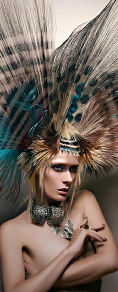 a woman with feathers on her head is posing