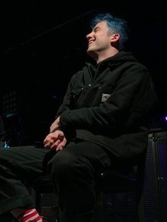 two men sitting next to each other on stage