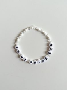 a white beaded bracelet with the word bride spelled in black letters on top of it