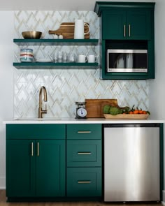 a kitchen with green cabinets and white tile backsplash, stainless steel dishwasher