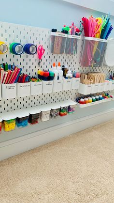 the wall is filled with craft supplies and storage bins for pens, pencils, markers