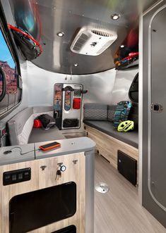 the interior of an rv with wood flooring and gray walls, including a bed