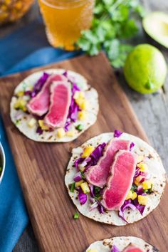 three tortillas on a cutting board with fruit and vegetables