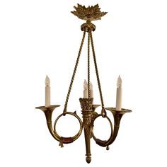 a chandelier with three candles hanging from it's sides and two arms