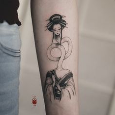 a woman's arm with a black and white tattoo design on the left forearm