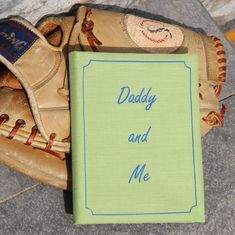 a baseball glove with a book that says daddy and me