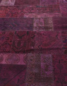 an old patchwork rug with many different colors and patterns on the floor, including pinks