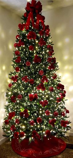 a christmas tree decorated with red roses and lights