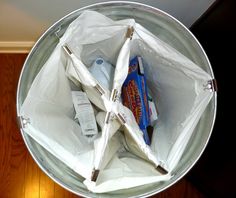 an open white bag filled with items on top of a wooden floor