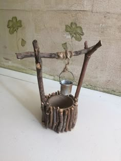 a candle holder made out of branches with a lantern hanging from it's side