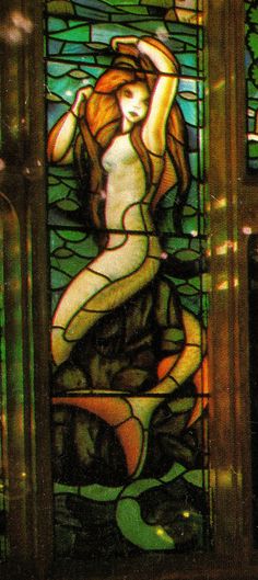 a stained glass window with a woman sitting on the ground in front of her body