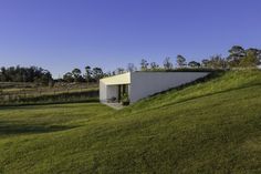 the house is built on top of a hill with grass growing up it's side