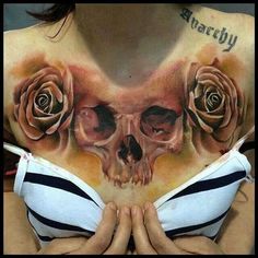 a woman's chest with a skull and roses on it