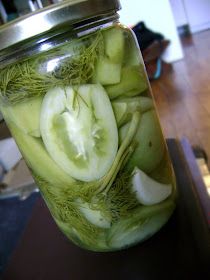 a jar filled with cucumbers on top of a wooden table