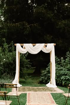 an outdoor wedding ceremony setup with white drapes