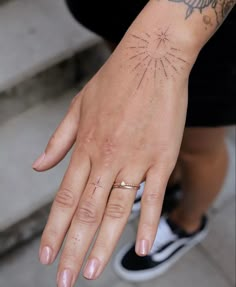 a person's hand with a tattoo on it and a ring in the middle