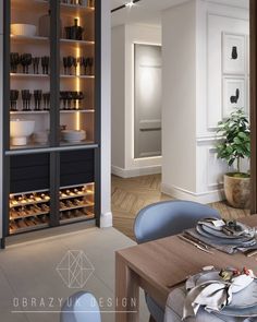 an empty dining room table with plates and utensils in the cabinet behind it