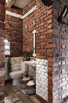 a bathroom with brick walls and flooring in the corner, along with a toilet