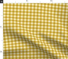 a yellow and white checkered fabric with a ruler in the foreground to show it's length