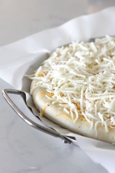 a pizza sitting on top of a white plate covered in cheese and grated parmesan