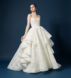 a woman in a white wedding dress standing on a blue background