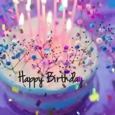 a birthday cake with lit candles and sprinkles